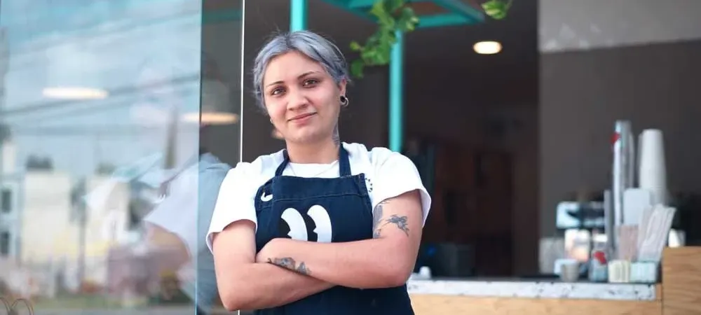 Shopowner in front of storefront counter
